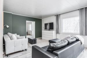 a living room with a couch and a tv at Santa's choice for Aurora hunters , Sauna and jacuzzi in Rovaniemi
