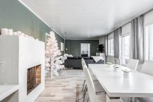 a dining room with a christmas tree and a fireplace at Santa's choice for Aurora hunters , Sauna and jacuzzi in Rovaniemi +43 photos
