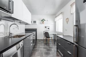 a kitchen with black counter tops and a table at Santa's choice for Aurora hunters , Sauna and jacuzzi in Rovaniemi