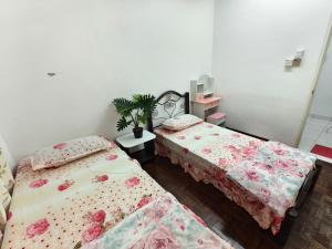 a bedroom with two beds and a potted plant at Dihome Ariel Twin Bed in Donggongon