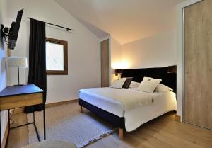 una camera da letto con un letto e una televisione di Mio – Loft alpin lumineux avec vue montagne a Champagny-en-Vanoise