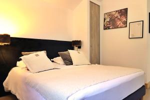 una camera da letto con un letto grande con lenzuola bianche di Mio – Loft alpin lumineux avec vue montagne a Champagny-en-Vanoise