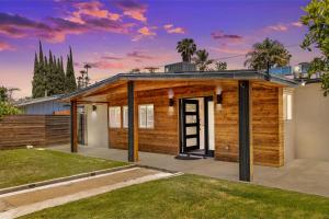a house with a wooden facade with a yard at Reseda 4BR Pool Villa Hot Tub Arcade & Biliard in Winnetka