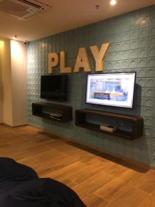 a tv on a wall with a play sign on it at Aqualand Resort in Salinópolis