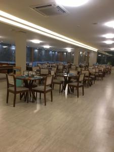 a dining room with tables and chairs in a building at Aqualand Resort in Salinópolis