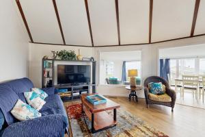 a living room with a blue couch and a tv at Neptune's Trident in Lincoln Beach +21 photos