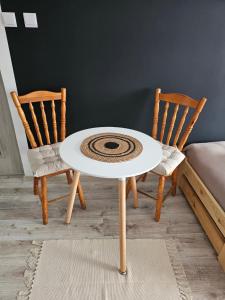 einen weißen Tisch und zwei Stühle in einem Zimmer in der Unterkunft Domowe Zacisze in Szamotuły + 9 Fotos