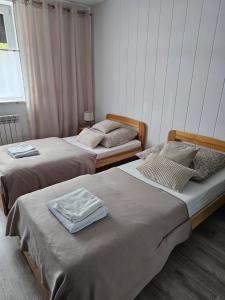 two twin beds in a room with at Domowe Zacisze in Szamotuły