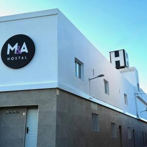 a building with a sign on the side of it at M&A Hostal in Bechí