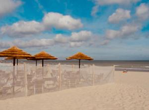 a group of chairs and umbrellas on a beach at Superb studio Malo-les-Bains in Dunkerque