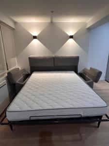 a large bed in a room with two chairs at Superb studio Malo-les-Bains in Dunkerque