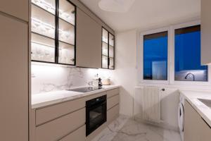 a kitchen with white counters and a sink and windows at Luxurious 3 Bedrooms Sauna Jacuzzi in Tinqueux