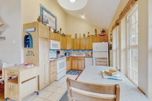 a kitchen with wooden cabinets and a table with a chair at Windsong in Rockaway Beach +20 photos
