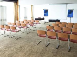 a room with rows of chairs and a podium at Novotel Macon Nord - Porte de Bourgogne in Mâcon +117 photos