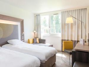 Ένα ή περισσότερα κρεβάτια σε δωμάτιο στο Novotel Le Mans