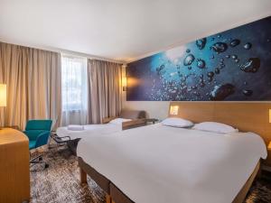 Ένα ή περισσότερα κρεβάτια σε δωμάτιο στο Novotel Le Mans