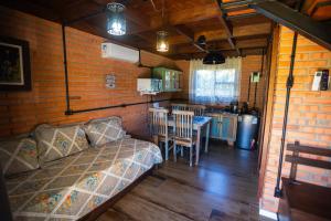 a bedroom with a bed and a kitchen with a table at Chalés Pomertraum in Pomerode +71 photos