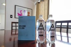 Dos botellas de agua sobre una mesa con un cartel de bienvenida a Urmia. en Industrial 3BR With OCEAN View, en Lima 18 fotos más