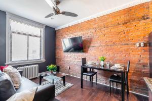 una sala de estar con una pared de ladrillo en 2 Bedroom Apt Near Downtown - King Bed Netflix, en Hamilton