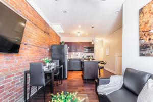 cocina y sala de estar con pared de ladrillo en 2 Bedroom Apt Near Downtown - King Bed Netflix, en Hamilton