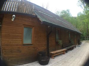 una cabaña de madera con un banco delante en Blazic I, en Maribor