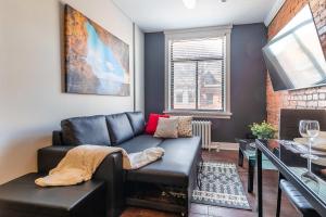 Una sala de estar con un sofá de cuero y una mesa. en 2 Bedroom Apt Near Downtown - King Bed Netflix, en Hamilton