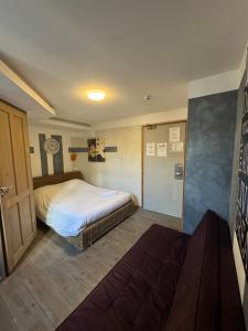 une chambre avec un lit et un canapé dans l'établissement Hôtel de France Tey Resort, à Lens