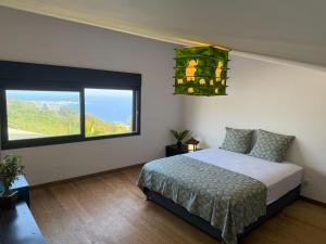 a bedroom with a bed and a large window at Villa Le Gillaou in La Possession