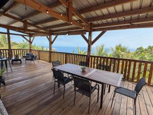 a wooden deck with a table and chairs on it at Villa Le Gillaou in La Possession