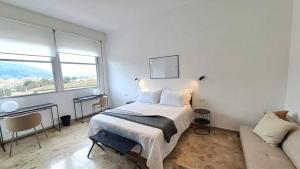 a white bedroom with a bed and a couch at Appartamento vicino a Firenze in Prato +18 photos
