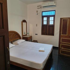 Un dormitorio con una gran cama blanca y una ventana. en Yali homestay, en Kuilapayam 24 fotos más