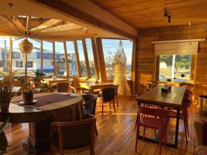 a restaurant with tables and chairs and windows at Hain Casa Hotel in Punta Arenas