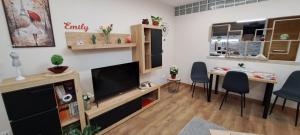 a living room with a television and a table and chairs at Emily Apartman Salgótarján in Salgótarján +27 photos