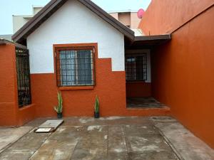 an orange and white house with two windows at Casa cerca de la playa in Ensenada