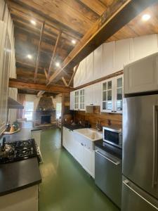 a large kitchen with white cabinets and stainless steel appliances at Sawdust City Haus in Gravenhurst