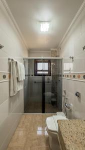 une salle de bain avec une douche, des toilettes et un lavabo dans l'établissement Pousada Vilage Inn Capivari Campos do Jordão, à Campos do Jordão