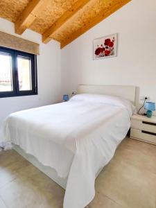 ein weißes Schlafzimmer mit einem großen weißen Bett in der Unterkunft Casa Rural Paseo de cuento in Villarquemado