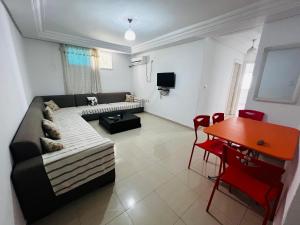 a living room with a couch and a table at Appartement 2 chambres à 250m de la plage, propre & bien équipé in Monastir
