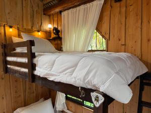 a bedroom with a bunk bed in a log cabin at Casa Colibri Chirripó in Herradura