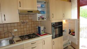 帕埃斯圖姆的住宿－Villa Claudianna Bed & Bike，厨房配有水槽、炉灶和冰箱