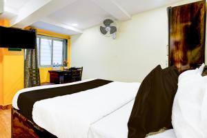 a bedroom with a large white bed and a desk at Hotel O Metro Galaxy inn in Mumbai +51 photos