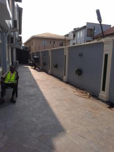 a person sitting on a bench in an alley at Zrico Hotels and Restaurant in Oke-Aro