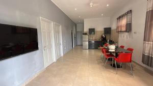 Nieuw NickerieZeedijk Resort Nickerie的厨房以及带桌子和红色椅子的用餐室。