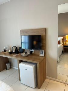a room with a desk with a tv and a refrigerator at Rio Centro Stay 1 in Rio de Janeiro +38 photos