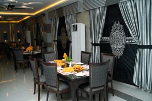 a dining room with a table and chairs and curtains at Sapphire Stays Hotel and Restaurant Peshawar in Peshawar