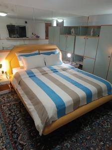 a bedroom with a large bed with blue and white stripes at Bolero apartman in Sarajevo