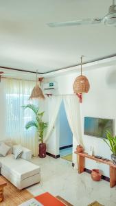 a living room with a white couch and a tv at ZANZIBAR MAREA Luxury Villas in Kiwengwa