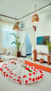 a bedroom with a large bed with red roses on it at ZANZIBAR MAREA Luxury Villas in Kiwengwa