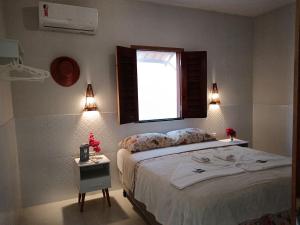 Schlafzimmer mit einem Bett, einem Fenster und Lichtern in der Unterkunft Casa Rosa in Praia de Moitas