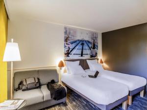 a hotel room with two beds and a couch at Novotel Metz Amnéville in Maizières-lès-Metz +168 photos